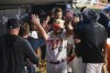Minnesota Twins' Kyle Farmer (12) celebrates in the dugout after scoring on a double by Jorge Polanco against the Cleveland Guardians during the seventh inning of a baseball game, Friday, June 2, 2023, in Minneapolis. (AP Photo/Craig Lassig)
