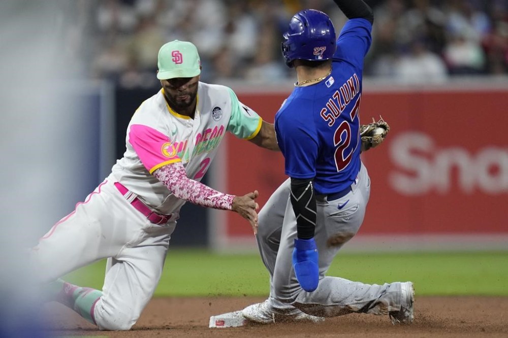 San Diego Padres shortstop Xander Bogaerts, left, tags out Chicago Cubs' Seiya Suzuki, as Suzuki is caught stealing second base during the fifth inning of a baseball game Friday, June 2, 2023, in San Diego. (AP Photo/Gregory Bull)