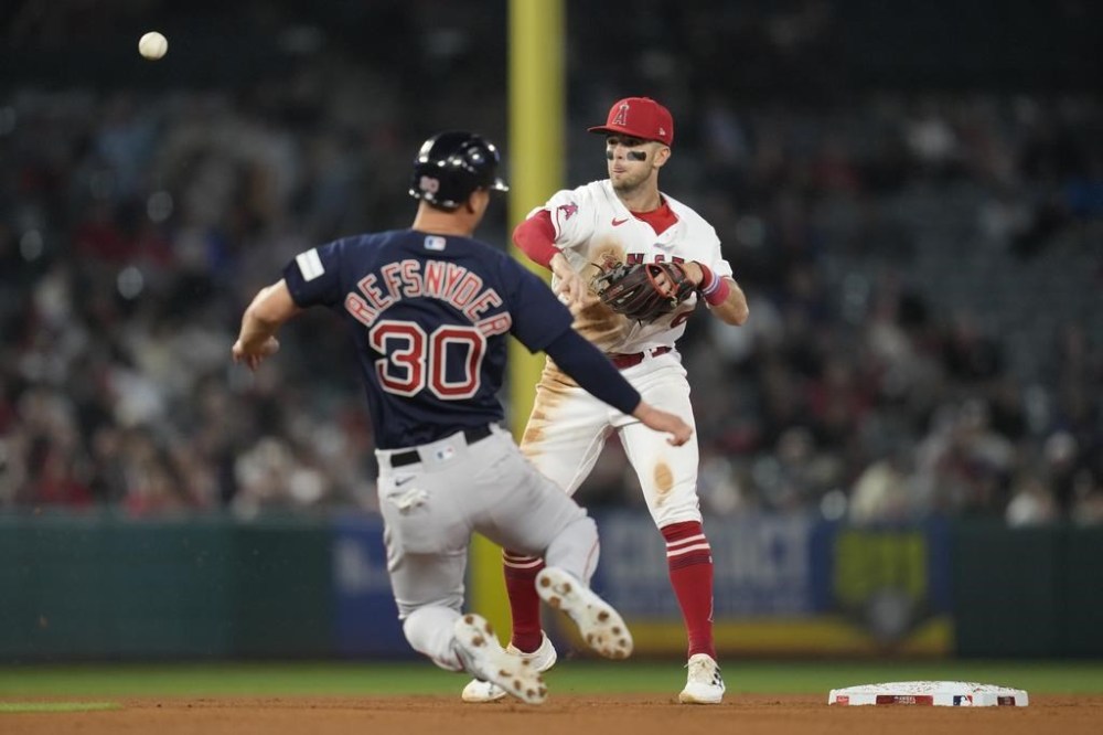 Los Angeles Angels shortstop Zach Neto (9) throws to first after Boston Red Sox's Rob Refsnyder (30) is out at second during the eighth inning of a baseball game in Anaheim, Calif., Tuesday, May 23, 2023. Alex Verdugo was safe at first. (AP Photo/Ashley Landis)