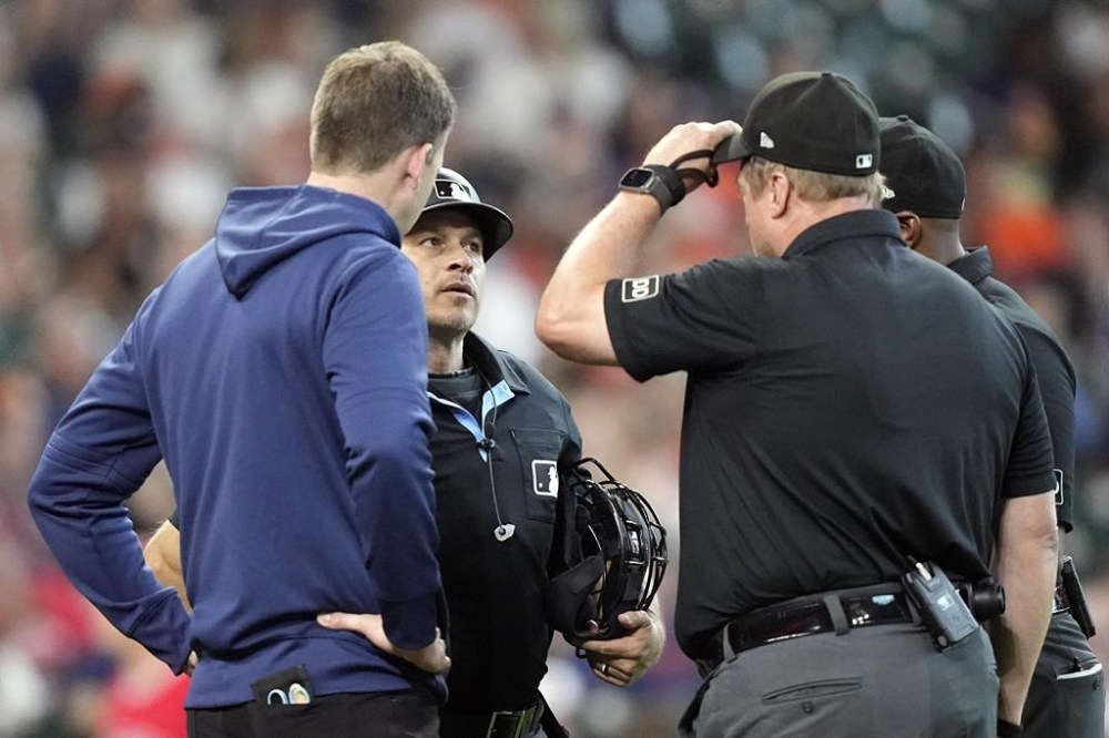 Home plate umpire Mark Wegner, second from left, talks with fellow umpires before leaving the game during the eighth inning of a baseball game Saturday, June 3, 2023, in Houston. Wegner was hit by a foul ball in the seventh inning. (AP Photo/David J. Phillip)