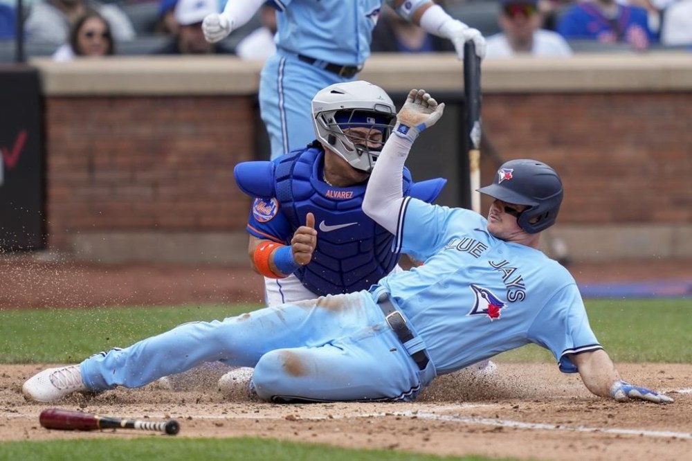 Toronto Blue Jays' Matt Chapman, right, beats the tag at home to score against New York Mets catcher Francisco Alvarez (4) in the third inning of a baseball game, Sunday, June 4, 2023, in New York. (AP Photo/John Minchillo)