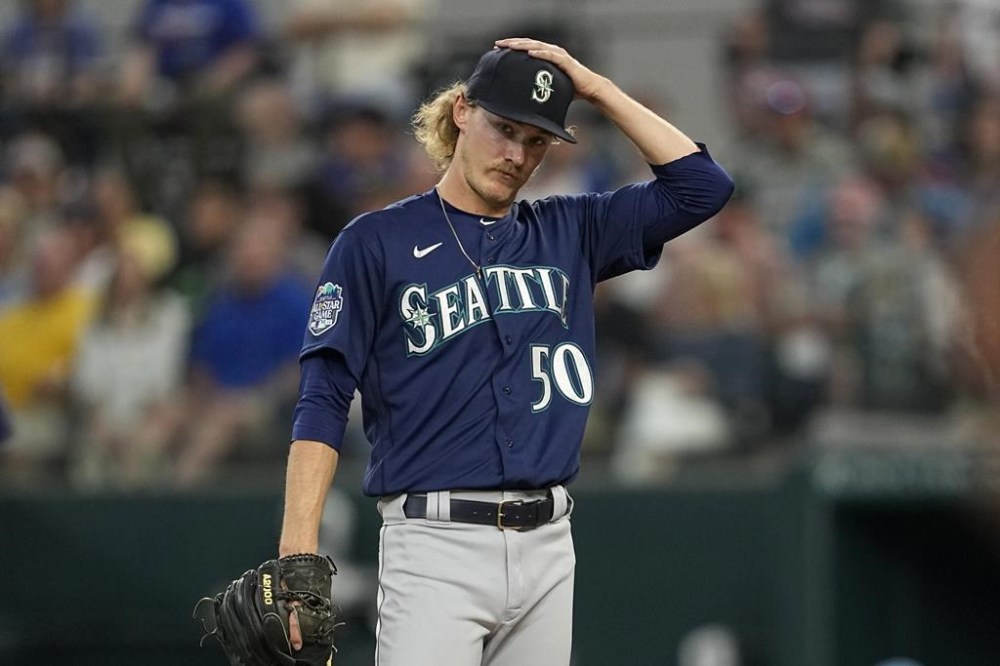 Seattle Mariners starting pitcher Bryce Miller adjust his cap as he stands on the mound while waiting to be pulled in the third inning of a baseball game against the Texas Rangers, Sunday, June 4, 2023, in Arlington, Texas. (AP Photo/Tony Gutierrez)