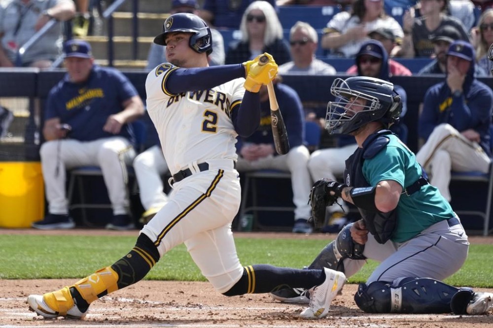 FILE - Milwaukee Brewers' Luis Urias, left, follows through on a swing as Seattle Mariners catcher Tom Murphy, right, looks on during the first inning of a spring training baseball game March 5, 2023, in Phoenix. Urías has been activated from the injured list, over two months after he hurt his hamstring on the opening day of the season. The Brewers activated Urías, Monday, June 5, 2023. (AP Photo/Ross D. Franklin, File)