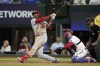 St. Louis Cardinals' Jordan Walker follows through on a solo home run next to Texas Rangers' Mitch Garver and umpire Nestor Ceja during the sixth inning of a baseball game Tuesday, June 6, 2023, in Arlington, Texas. (AP Photo/Tony Gutierrez)