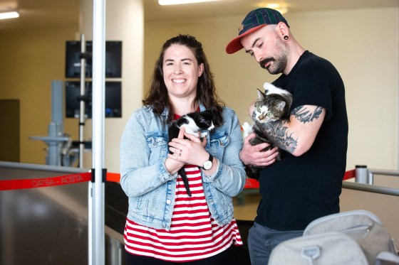 Eva Wasney and her partner, Neal Leithead, hold kittens from K9 Advocates Manitoba as the crates are scanned before going on a plane to Toronto. (Mikaela MacKenzie / Winnipeg Free Press)