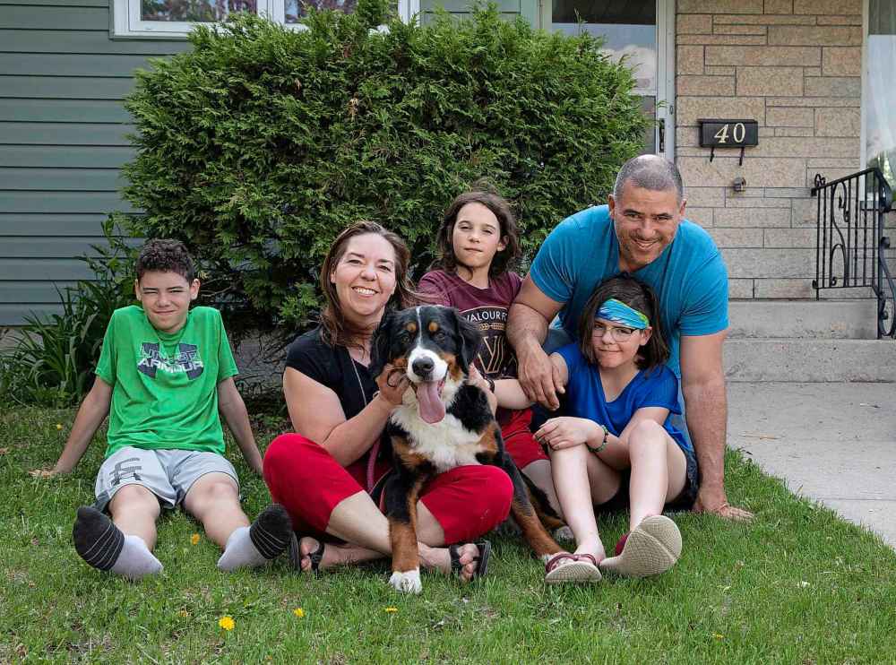 The Melo family, from left: Xavier, 13, Sarah, Minnie, Ramone, 9, Savannah, 11, and Steve, are glad to have Minnie back after the dog escaped and boarded a Transit bus. (Jessica Lee / Winnipeg Free Press)