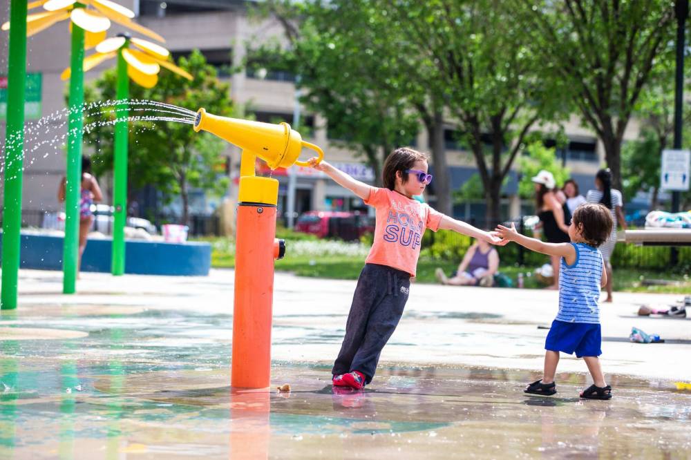 MIKAELA MACKENZIE / WINNIPEG FREE PRESS
Lake Fox (left, four) and his brother Luxton (one) Komaransky cool off at the splash pad in Central Park on Friday.