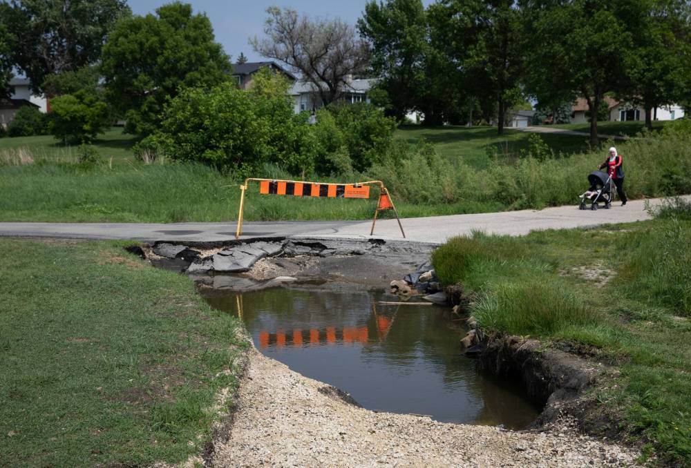JESSICA LEE / WINNIPEG FREE PRESS
The roughly 75-centimetre-deep depression, that stretches at least six metres, has now been fenced off.