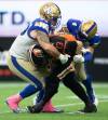 DARRYL DYCK / THE CANADIAN PRESS FILES
                                Casey Sayles (left) and Adam Bighill team up to sack B.C. QB Michael Reilly during CFL action in 2021.