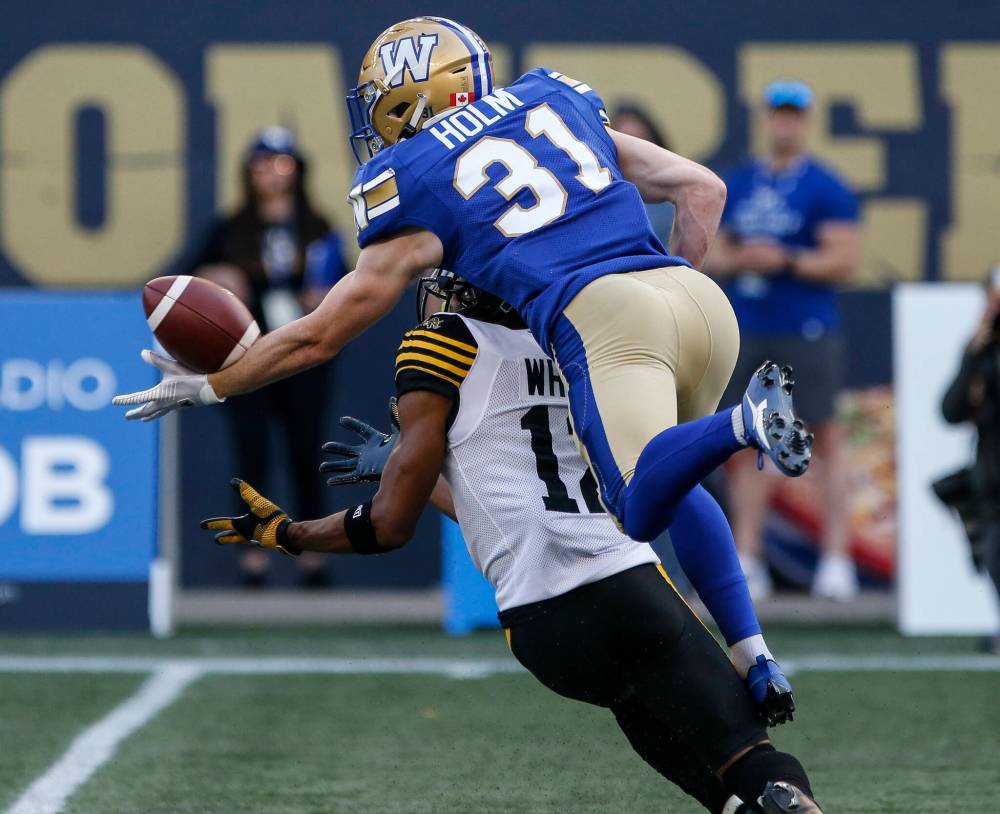 John Woods / THE CANADIAN PRESS
Winnipeg’s Evan Holm knocks down the pass intended for Ticats receiver Tim White Friday night at IG Field.