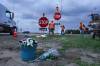 Hydro workers replace a stop sign in front of a small memorial at the corner of Highway 1 and Highway 5 Friday afternoon. (Ruth Bonneville / Winnipeg Free Press)