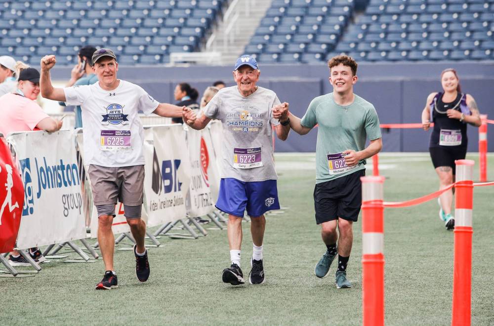 JOHN WOODS / WINNIPEG FREE PRESS
Rick Bochinski, 55, with his dad, 81-year-old Garry, and son Michael, 25, finish their run together in the 45th Manitoba Marathon Sunday.