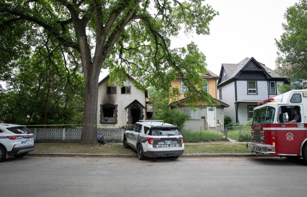 JESSICA LEE / WINNIPEG FREE PRESS
On Wednesday, police cruisers remained parked on Furby Street and the lane behind the house, which was blocked off with yellow caution tape.