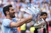 Manchester City's Ilkay Gundogan holds up the winners trophy as he celebrates winning the English FA Cup final soccer match between Manchester City and Manchester United at Wembley Stadium in London, Saturday, June 3, 2023. Manchester City won 2-1. (AP Photo/Dave Thompson)