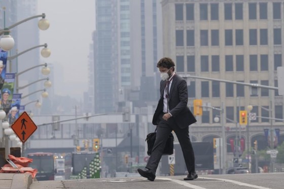 A man walks to work wearing a mask near Parliament Hill, Wednesday, in Ottawa. (Adrian Wyld / The Canadian Press)
