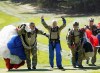 FILE - LIV Golf CEO Greg Norman, center, gives up a thumbs-up after parachuting in with the Frog-X Navy Seal parachute team before the first round of the LIV golf tournament, Sept. 2, 2022, in Bolton, Mass. LIV is funded by Saudi Arabia's wealth fund which now has a commercial deal with the PGA Tour and European tour. (AP Photo/Mary Schwalm, File)