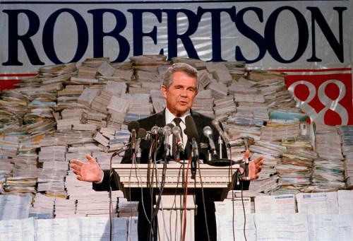 FILE - Pat Robertson, stands in front of stacks of signatures as he announced his intentions to collect a total of 7 million signatures during a news conference on Sept. 15, 1987 in Chesapeake, Va. Robertson, a religious broadcaster who turned a tiny Virginia station into the global Christian Broadcasting Network, tried a run for president and helped make religion central to Republican Party politics in America through his Christian Coalition, has died. He was 93. Robertson's death Thursday, June 8, 2023 was announced by his broadcasting network. (AP Photo/Steve Helber, file)