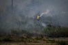 A firefighter directs water on a grass fire on an acreage behind a residential property in Kamloops, British Columbia, Monday, June 5, 2023. For the first time this year, air quality advisories are posted for part of Vancouver Island and a large section of the Lower Mainland as smoke from several wildfires wafts over the region. THE CANADIAN PRESS/Darryl Dyck