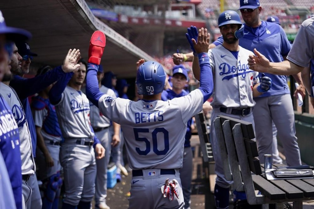 Los Angeles Dodgers' Mookie Betts (50) celebrates with teammates after scoring on a single by David Peralta in the third inning of a baseball game against the Cincinnati Reds in Cincinnati, Thursday, June 8, 2023. (AP Photo/Jeff Dean)