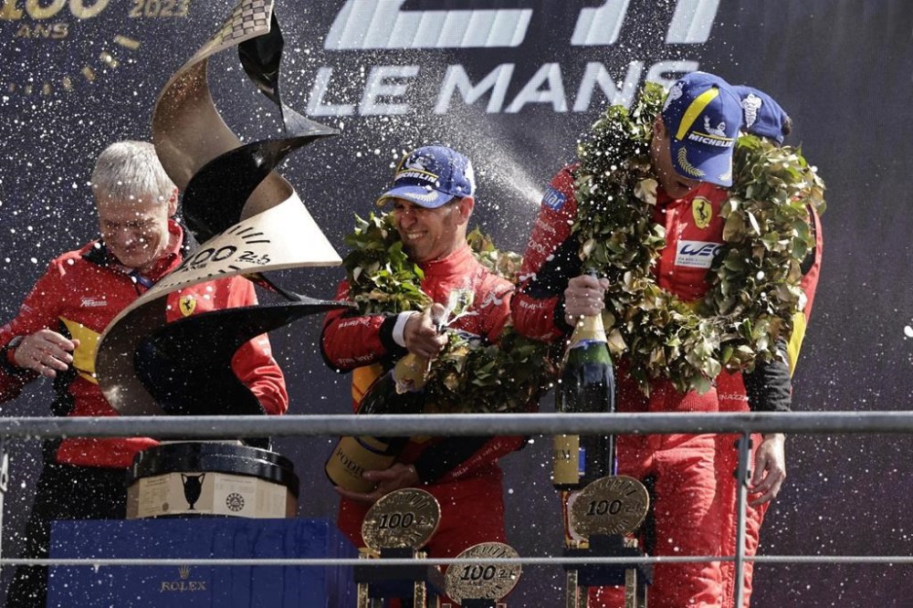 Ferrari AF Corse drivers Antonio Giovinazzi, covered, Alessandro Pier Guidi, centre, from Italy, and James Calado from Britain celebrate their victory at the 24-hour Le Mans endurance race in Le Mans, western France, Sunday, June 11, 2023. (AP Photo/Jeremias Gonzalez)