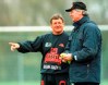FILE - Coach Clive Barker of South Africa's national soccer team, left, and coach Uli Maslo of Germany's Second Division soccer team Fortuna Duesseldorf talk together during the practise session for South Africa at Duesseldorf's Rhine stadium, on Nov. 13, 1997. South Africa has been paying tribute to its first post-apartheid national soccer coach who died on Saturday at the age of 78. Clive Barker coached an inexperienced and little-known South Africa team to the African Cup of Nations title in 1996. (AP Photo/Horst Mueller, File)