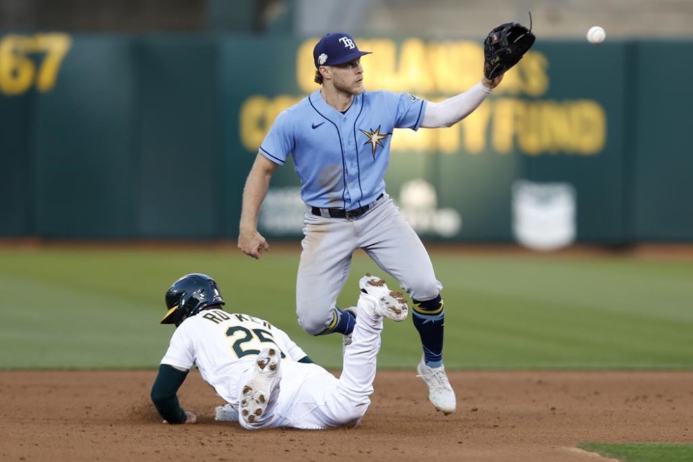 Oakland Athletics' Brent Rooker (25) dives into second on a pickoff-attempt by Tampa Bay Rays' Taylor Walls, right, during the fifth inning of a baseball game in Oakland, Calif., Monday, June 12, 2023. (AP Photo/Jed Jacobsohn)
