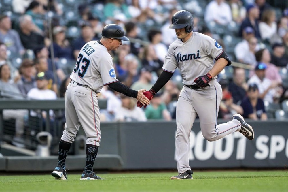 Miami Marlins' Nick Fortes, right, is congratulated by third base coach Jody Reed after hitting a solo home run off Seattle Mariners starting pitcher Bryce Miller during the fifth inning of a baseball game, Monday, June 12, 2023, in Seattle. (AP Photo/Stephen Brashear)