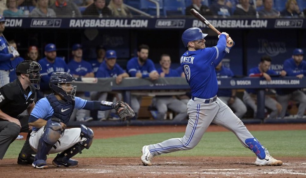 Toronto Blue Jays' Danny Jansen follows through on a double as home plate umpire Brennan Miller, left, and Tampa Bay Rays catcher Francisco Mejia watch during the fifth inning of a baseball game Tuesday, May 23, 2023, in St. Petersburg, Fla. Jansen was reinstated from the Jays 10-day injured list on Tuesday and he was available to play in Toronto's game versus the Orioles in Baltimore. THE CANADIAN PRESS/AP-Steve Nesius