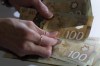 Canadian $100 bills are counted in Toronto, Feb. 2, 2016. Canadians are struggling to save for retirement, with many planning to push back the next phase of their life amid inflation and higher interest rates, according to a new survey from the Healthcare of Ontario Pension Plan. THE CANADIAN PRESS/Graeme Roy