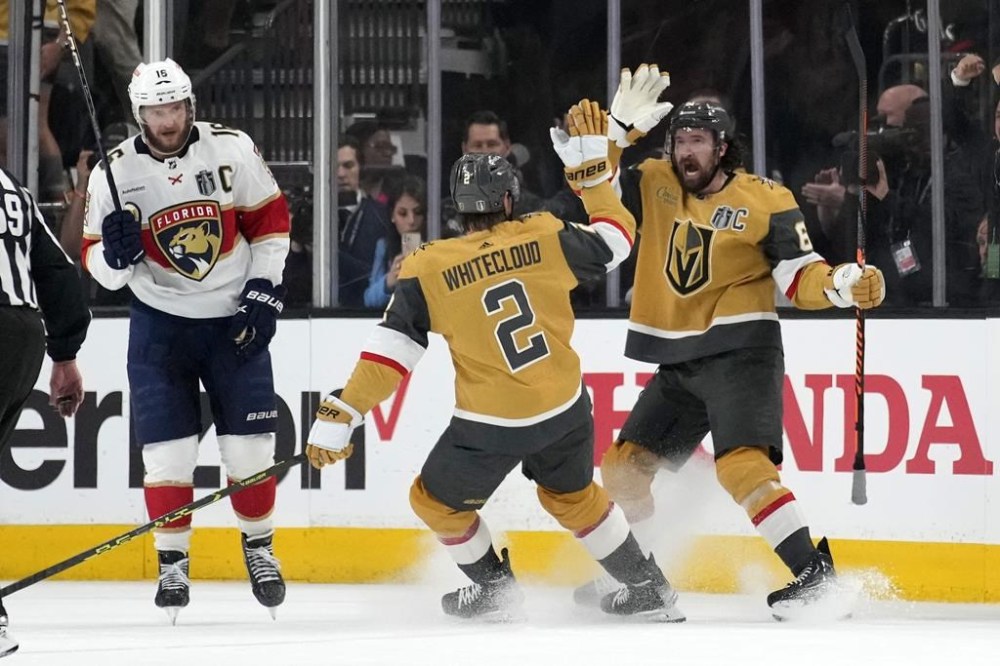 Las Vegas Golden Knights right wing Mark Stone, right, celebrates with defenceman Zach Whitecloud, centre, after scoring as Florida Panthers centre Aleksander Barkov skates away during the first period in Game 5 of the NHL hockey Stanley Cup Finals Tuesday, June 13, 2023, in Las Vegas. The Sioux Valley Dakota Nation in Manitoba is celebrating one of its own after Whitecloud and the Golden Knights won the Stanley Cup. THE CANADIAN PRESS/AP-John Locher