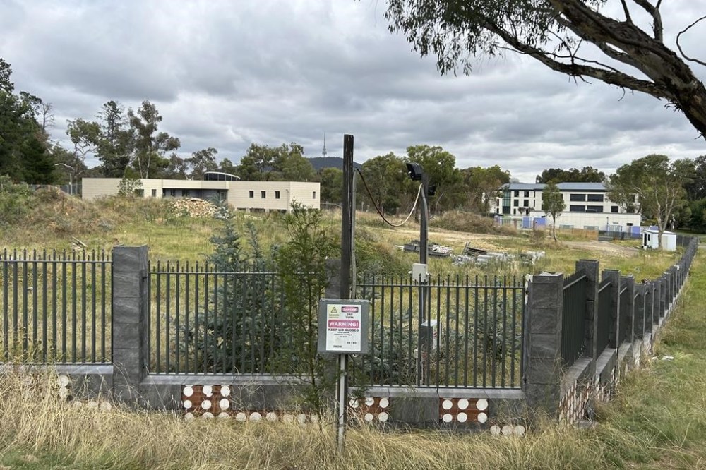 An unoccupied building, left, sits on the grounds of a proposed new Russian embassy, across from another building, right, that is part of the Chinese embassy near the Australian Parliament in Canberra, Feb. 28, 2023. Australia's House of Representatives passed legislation Thursday, June 15, 2023, to prevent Russia from building a new embassy near Parliament House on security grounds. (AP Photo/Rod McGuire)
