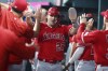 Los Angeles Angels' Mike Trout (27) is greeted in the dugout after scoring against the Texas Rangers during the third inning of a baseball game Wednesday, June 14, 2023, in Arlington, Texas. (AP Photo/Richard W. Rodriguez)