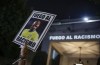 FILE - A protester holds up a photo of Brazilian soccer star Vinicius Jr and a message that reads in Portuguese; 