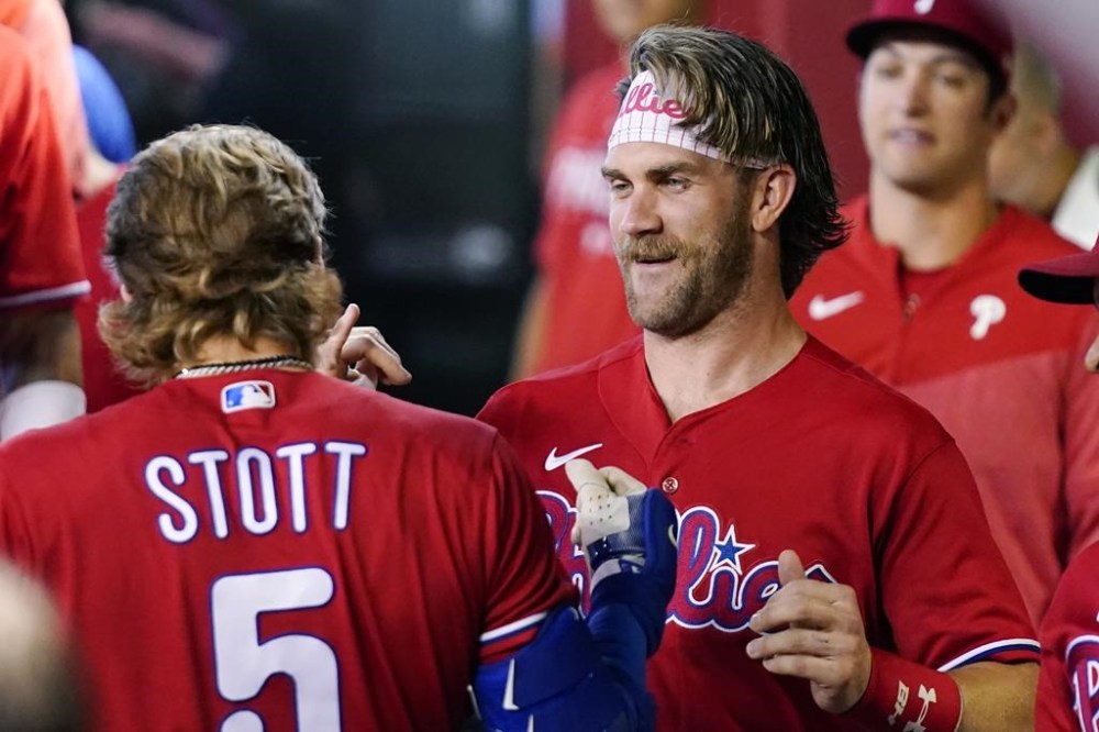 Philadelphia Phillies' Bryson Stott (5) celebrates his home run against the Arizona Diamondbacks with Phillies' Bryce Harper, right, during the second inning of a baseball game Thursday, June 15, 2023, in Phoenix. (AP Photo/Ross D. Franklin)