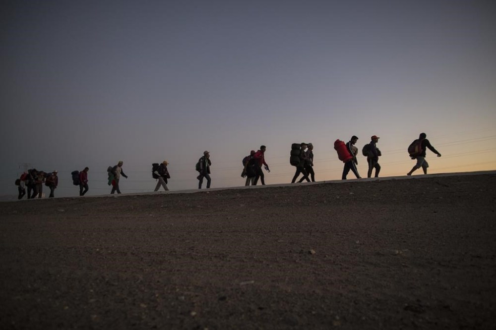 FILE - Central American migrants walk in the late afternoon as they leave Mexicali, Mexico, Nov. 20, 2018, on their way to Tijuana. The U.S. Treasury on June 16, 2023 announced sanctions on the Mexico-based migrant-trafficking gang known as the Hernandez Salas organization, based in Mexicali, that supplied asylum seekers with false papers to game the process since at least 2018, according to the Treasury Department. The gang then smuggled the migrants into the U.S. (AP Photo/Rodrigo Abd, File)
