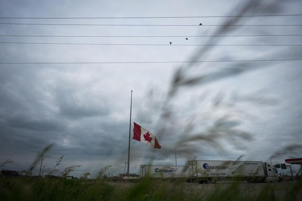 A Canadian flag flies at half-mast at a truck stop in Brandon Friday. (Darryl Dyck / The Canadian Press)