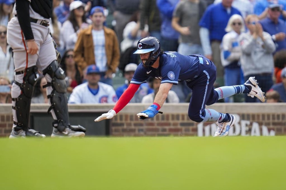 Chicago Cubs' Dansby Swanson dives into home base to score during the sixth inning of a baseball game against the Baltimore Orioles, Friday, June 16, 2023, in Chicago. (AP Photo/Erin Hooley)