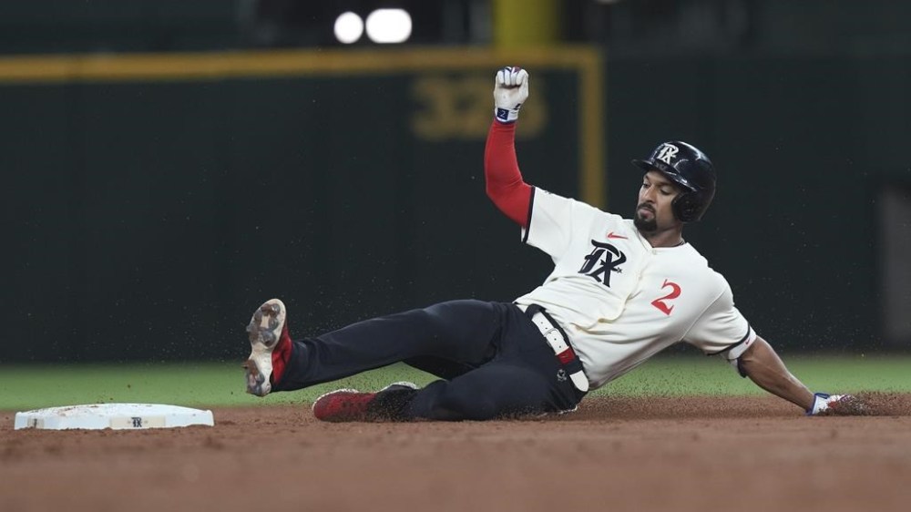 Texas Rangers' Marcus Semien slides into second base with a double during the third inning of the team's baseball game against the Toronto Blue Jays in Arlington, Texas, Friday, June 16, 2023. (AP Photo/LM Otero)