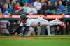 Miami Marlins' Jean Segura dives home to score on a sacrifice fly hit by Jonathan Davis against the Seattle Mariners during the eighth inning of a baseball game Wednesday, June 14, 2023, in Seattle. (AP Photo/John Froschauer)