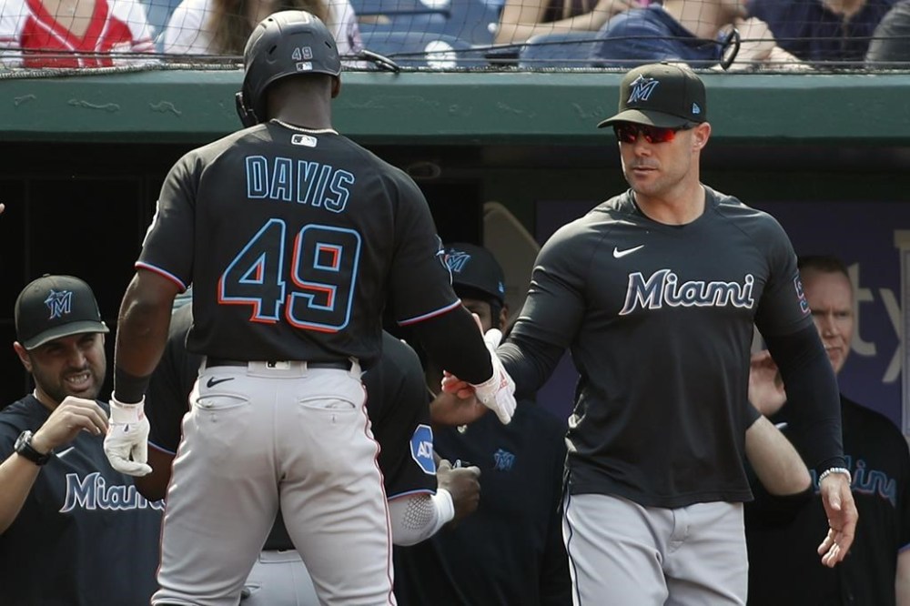 Miami Marlins' Jonathan Davis (49) celebrates with manager Skip Schumaker, right, after hitting a sacrifice fly that scored Jesús Sánchez during the second inning of a baseball game against the Washington Nationals, Saturday, June 17, 2023, in Washington. (AP Photo/Luis M. Alvarez)