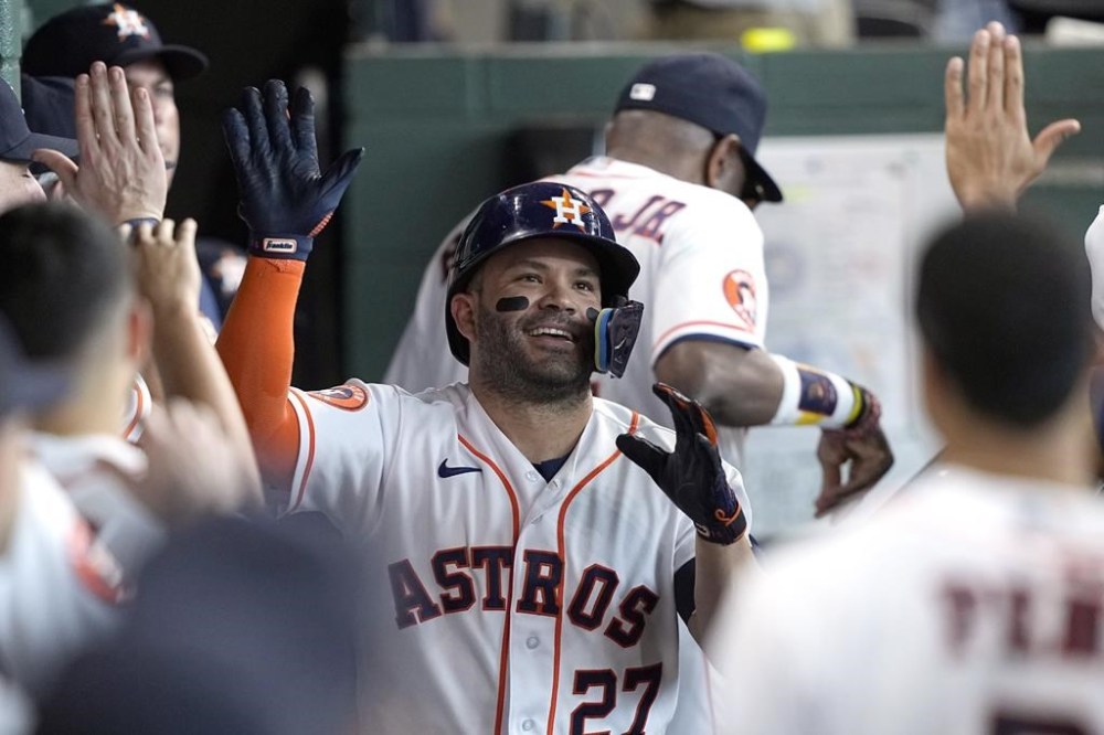 Houston Astros' Jose Altuve (27) celebrates in the dugout after hitting a home run against the Cincinnati Reds during the seventh inning of a baseball game Saturday, June 17, 2023, in Houston. (AP Photo/David J. Phillip)