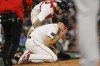 Boston Red Sox starting pitcher Tanner Houck kneels on the mound, bleeding after being struck on the cheek by a line drive by of New York Yankees' Kyle Higashioka during the fifth inning of a baseball game Friday, June 16, 2023, at Fenway Park in Boston. (AP Photo/Winslow Townson)