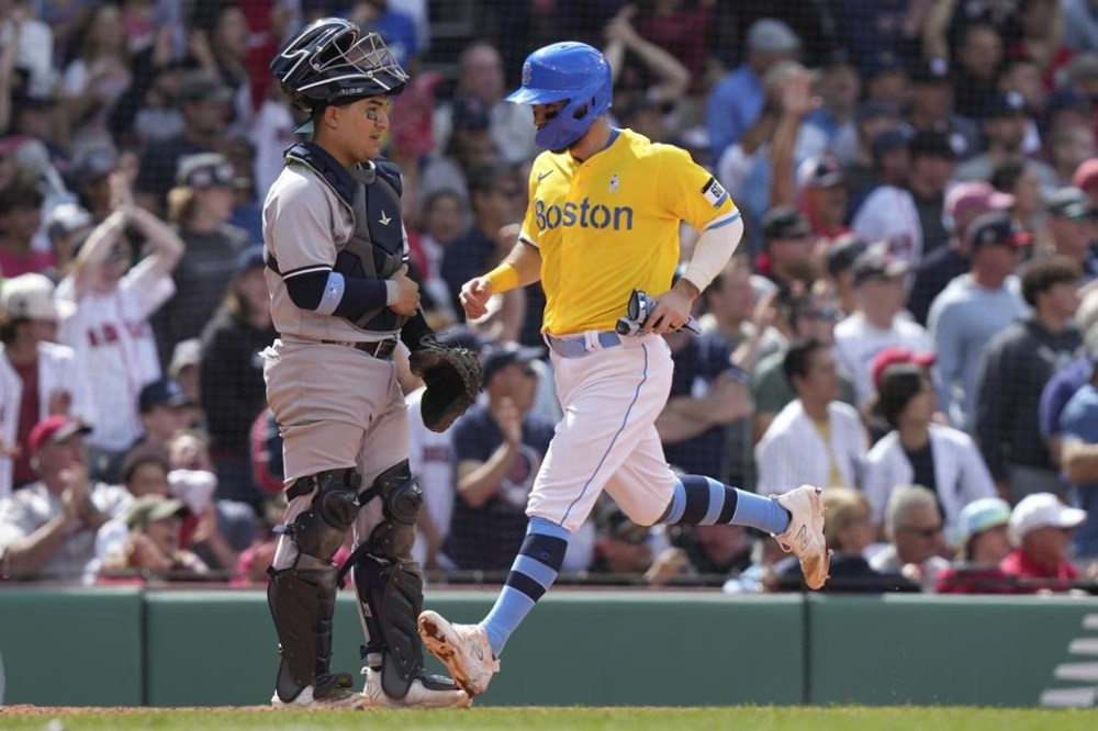 Boston Red Sox's Connor Wong, right, crosses home plate in front of New York Yankees' Jose Trevino, left, to score on a double by Red Sox's Alex Verdugo in the sixth inning of a baseball game, Sunday, June 18, 2023, in Boston. (AP Photo/Steven Senne)