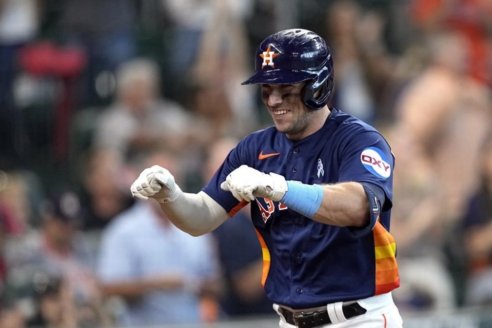 Houston Astros' Alex Bregman celebrates after scoring on a triple and throwing error by Cincinnati Reds second baseman Jonathan India during the fourth inning of a baseball game Sunday, June 18, 2023, in Houston. (AP Photo/David J. Phillip)