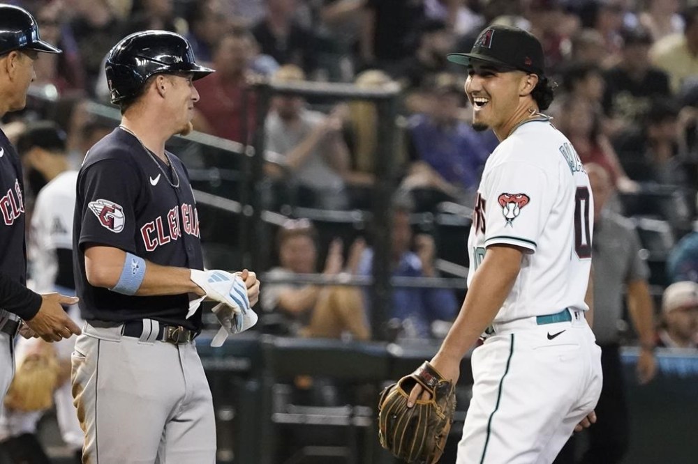 Cleveland Guardians' Myles Straw, left, laughs with Arizona Diamondbacks third baseman Josh Rojas who pitched during the ninth inning of a baseball game Sunday, June 18, 2023, in Phoenix. (AP Photo/Darryl Webb)