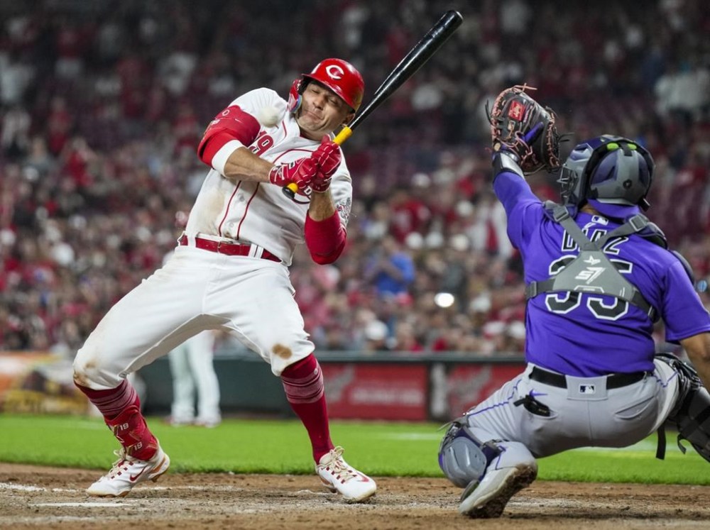 Cincinnati Reds' Joey Votto, left, reacts to a pitch during the eighth inning of a baseball game against the Colorado Rockies in Cincinnati, Monday, June 19, 2023. (AP Photo/Aaron Doster)