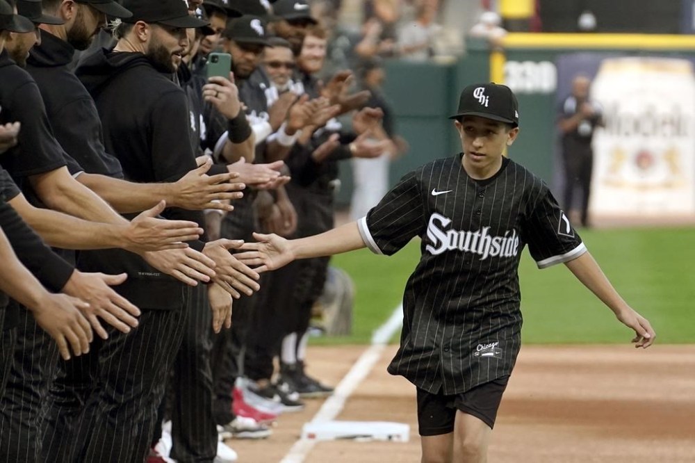Cancer patient Brady Nelson participates in the Chicago White Sox's Ultimate Wish program as he runs the bases and is greeted by members of the baseball club before a baseball game between the White Sox and the Texas Rangers Monday, June 19, 2023, in Chicago. (AP Photo/Charles Rex Arbogast)