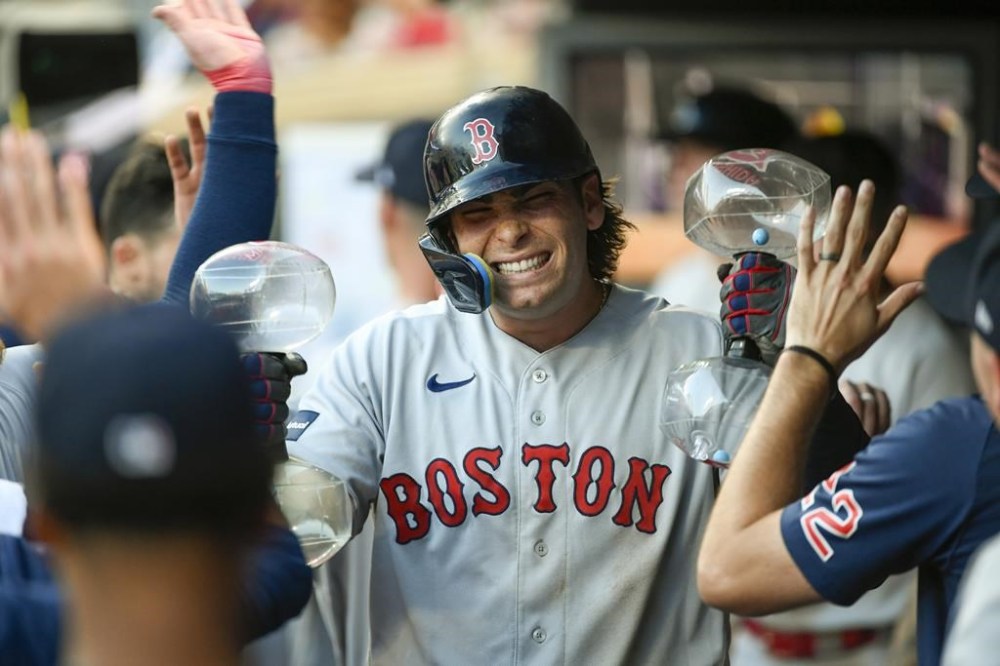 Boston Red Sox's Triston Casas celebrates in the dugout after hitting a two-run home run against the Minnesota Twins during the seventh inning of a baseball game, Monday, June 19, 2023, in Minneapolis. (AP Photo/Craig Lassig)