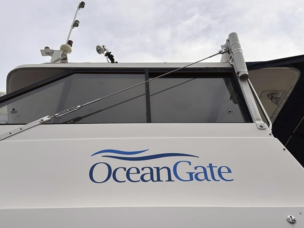 The logo for OceanGate Expeditions is seen on a boat parked near the offices of the company at a marine industrial warehouse office door in Everett, Wash., Tuesday, June 20, 2023. Rescuers raced against time to find the missing submersible carrying five people, who were reported overdue Sunday night. (AP Photo/Ed Komenda)