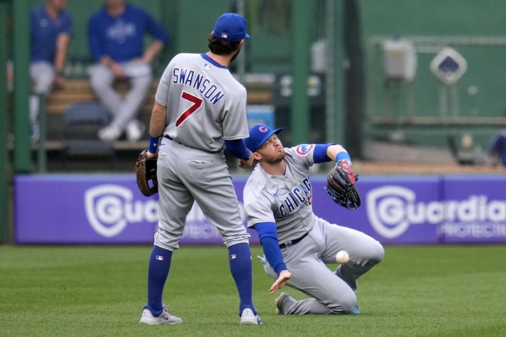 Chicago Cubs left fielder Ian Happ can't handle a fly ball hit by Pittsburgh Pirates' Ke'Bryan Hayes during the first inning of a baseball game in Pittsburgh, Tuesday, June 20, 2023. At left is shortstop Dansby Swanson. (AP Photo/Gene J. Puskar)
